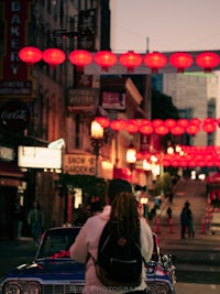 a man walking down a street with a car in front of him